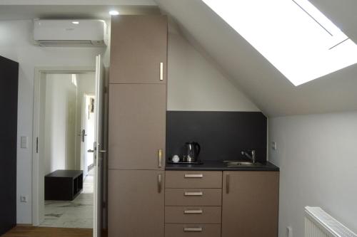 a kitchen with a sloping ceiling with a skylight at Rosbacher nun Residenz in Rosbach vor der Höhe