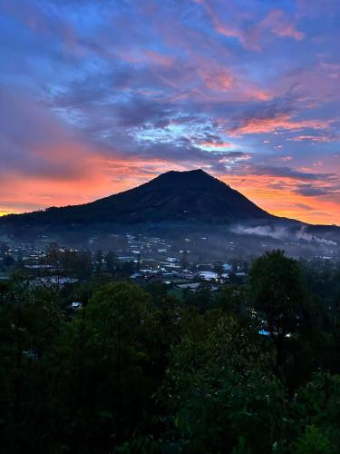 a view of a mountain with a city at sunset at Batur cottage in Kubupenlokan