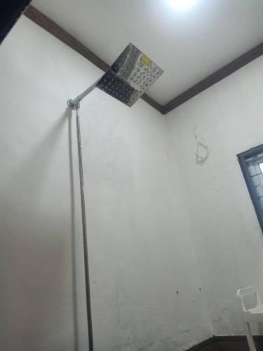 a floor lamp in a room with a white wall at D'semporna Homestay in Semporna
