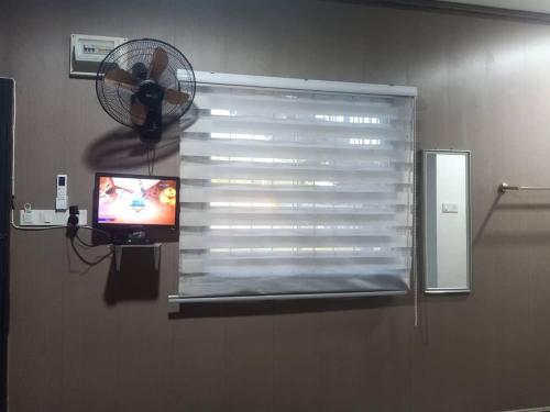 a window with a fan and a television in a room at D'semporna Homestay in Semporna