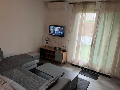 un salon avec un canapé et une télévision à écran plat dans l'établissement Maison bord de mer, à La Seyne-sur-Mer