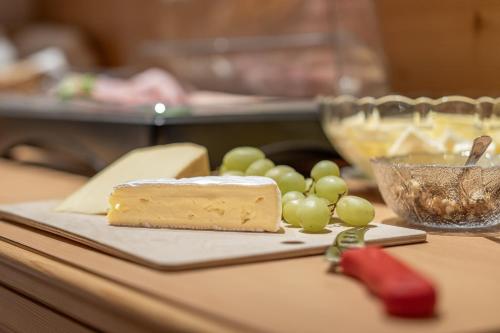 a piece of cheese and grapes on a table at Haus Gstrein in Obergurgl