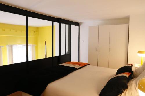 - une chambre avec un grand lit blanc et des fenêtres dans l'établissement Monnaie,Vieux-Lille, Unique, Neo-Vintage, à Lille