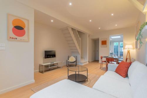 un salon avec un canapé blanc et une table dans l'établissement Maison 2 chambres calme, proche tram, à Mouvaux