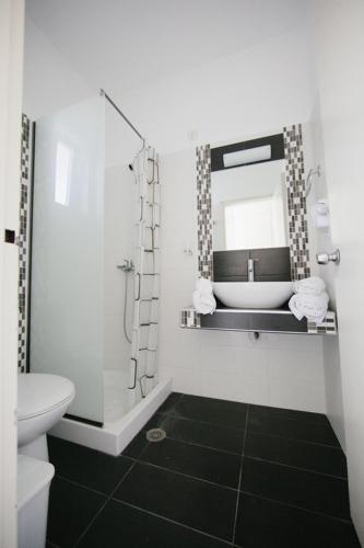 a bathroom with a sink and a toilet and a mirror at Artemis Comfort&Pleasure in Faliraki