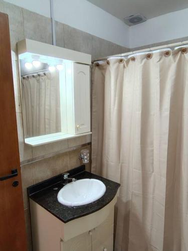 a bathroom with a sink and a shower curtain at Rooftop Velez Sarsfield in Buenos Aires
