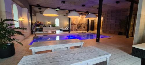 a swimming pool in a room with a table and a table at Hotel 1622 - Spa, Hotell & Konferens in Helsingborg