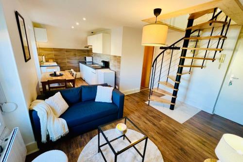 un salon avec un canapé bleu et une cuisine dans l'établissement Beautiful T3 close to the slopes, à Gérardmer