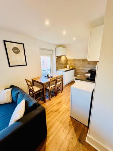 Il dispose d'une cuisine et d'un salon avec un canapé et une table. dans l'établissement Beautiful T3 close to the slopes, à Gérardmer