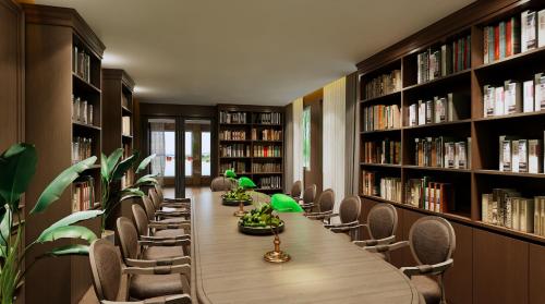 a library with a long table and chairs and bookshelves at Berghof am See in Langelsheim