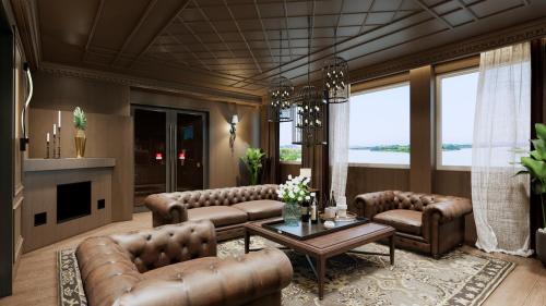 a living room with leather couches and a table at Berghof am See in Langelsheim