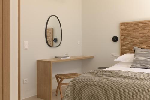 a bedroom with a bed and a mirror on the wall at VK Villas - Votsalo & Kyma Villas, By ThinkVilla in Léntas