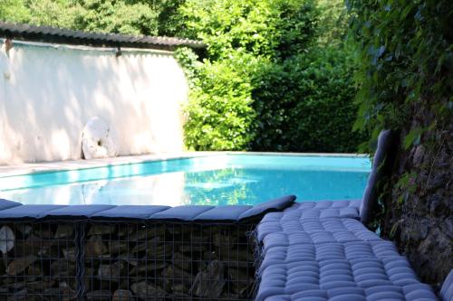 - une piscine dans une arrière-cour avec un chien assis à côté dans l'établissement Camping Moulin De Chaules, à Saint-Constant