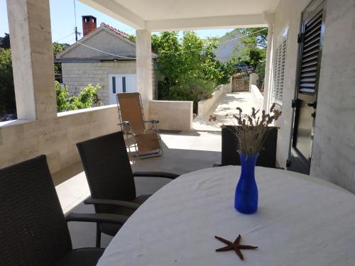 un jarrón azul sentado en una mesa en un patio en Holiday House Soline, en Veli Rat