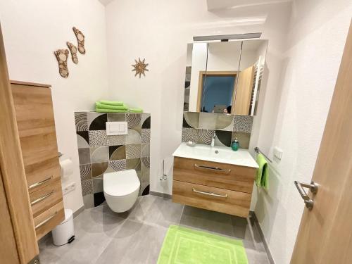 a bathroom with a sink and a toilet and a mirror at Haus Anne und Peter in Fischbach