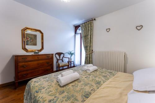 a bedroom with a bed with two towels on it at Fuori da ZTL - Asiago a due passi da tutto in Asiago