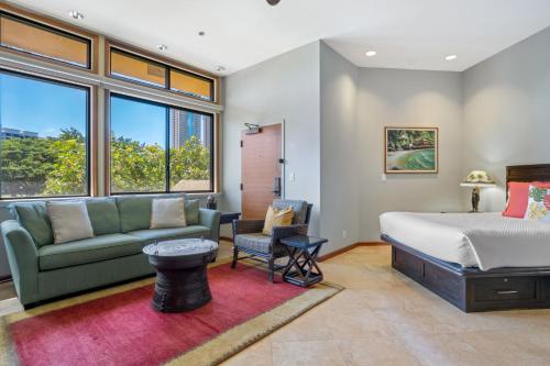 a bedroom with a bed and a couch at Luana Waikiki Hotel & Suites in Honolulu