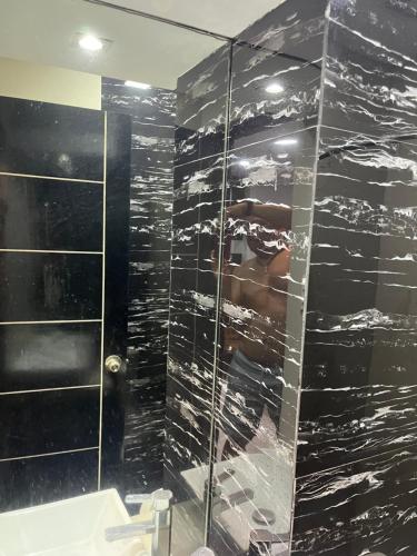 un bagno con doccia con parete in vetro di kap's che rental a Manila