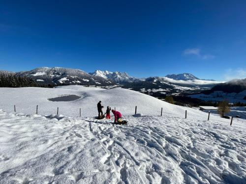 a group of people standing on top of a snow covered slope at Bioberghof Rohr in Fieberbrunn