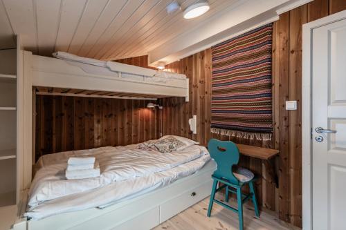 a bedroom with a bunk bed and a blue chair at Sunny and beautiful cabin in Geilo in Geilo
