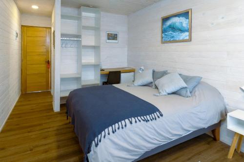 a bedroom with a bed and a desk in it at Viento Bravo Hotel Boutique & Spa in Pichilemu