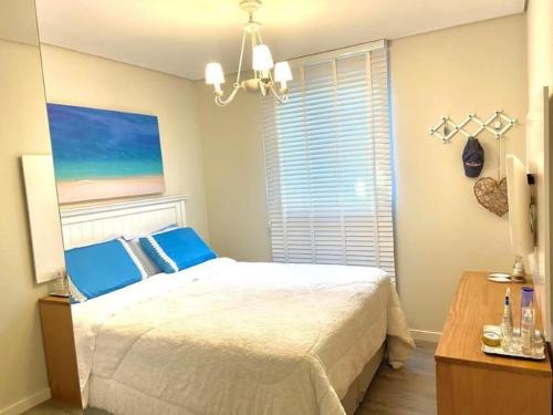 a bedroom with a bed and a painting on the wall at RCM Vilas - Porto Picarras in Piçarras