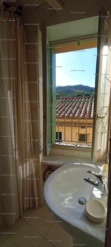 La salle de bains est pourvue d'un lavabo et d'une fenêtre avec vue. dans l'établissement 4SOL25 - Collioure charmante maison de village 150 m de la plage, à Collioure