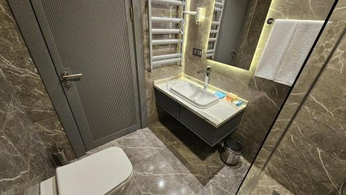 a bathroom with a sink and a toilet at VE Hotels Adakale in Yenişehir