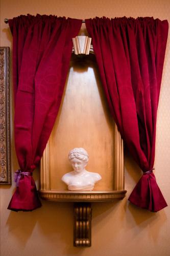 a statue in a window with red curtains at Hotel Rouge in Blackpool