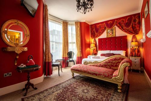 a bedroom with red walls and a bed and a mirror at Hotel Rouge in Blackpool