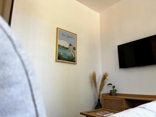 a bedroom with a flat screen tv on a wall at Le Ginkgo in Autun