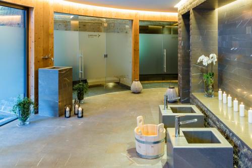 a bathroom with two sinks in a room with windows at The Alpina Mountain Resort in Tschiertschen