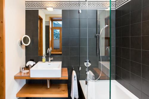 a bathroom with a sink and a shower at The Alpina Mountain Resort in Tschiertschen