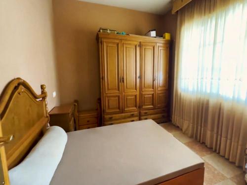 a bedroom with a bed and a wooden cabinet at Exclusive Apartments with Panoramic Views and Unique Interiors in Los Gallardos