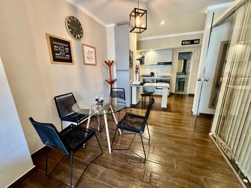 a dining room with a glass table and chairs at The Best in Camba Cua, A metros de la costanera y del centro de la ciudad, ubicacion inmejorable, cerca de la playa, a 2 cuadras parque Cambacua dpto moderno, completamente equipado, con balcon, con todo lo necesario para una estadia comoda y placentera in Corrientes