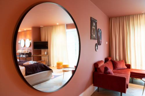 a bedroom with a mirror and a bed and a couch at Van der Valk Hotel Apeldoorn in Apeldoorn