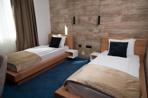 a hotel room with two beds and a wall at Hotel Borovi Forest Resort & Spa in Sjenica
