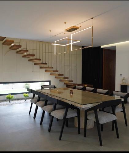 a dining room with a table and chairs and a staircase at Marrakech Oasis Retreat - 5-Bedroom Villa with Private Pool in El Makina
