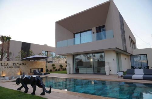 a house with a statue of a dog by a swimming pool at Marrakech Oasis Retreat - 5-Bedroom Villa with Private Pool in El Makina