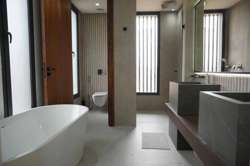 a bathroom with a tub and a sink and a toilet at Marrakech Oasis Retreat - 5-Bedroom Villa with Private Pool in El Makina