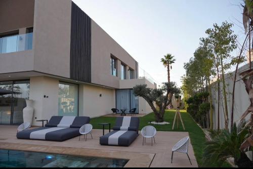 a house with two couches and chairs next to a pool at Marrakech Oasis Retreat - 5-Bedroom Villa with Private Pool in El Makina
