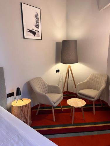 a room with two chairs and a table and a lamp at Hotel i Restauracja Czarny Kos in Borkowo