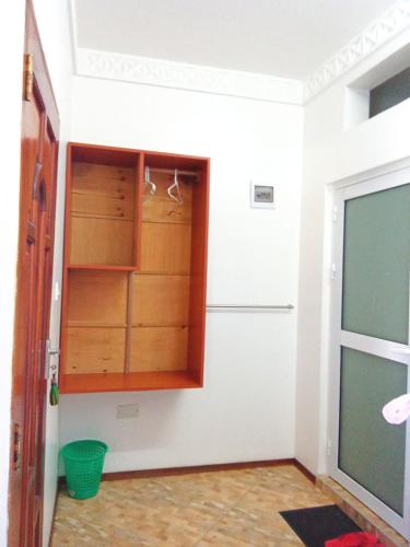 a kitchen with wooden cabinets and a refrigerator at Milalana Guest Hotel & Residences in Malindi