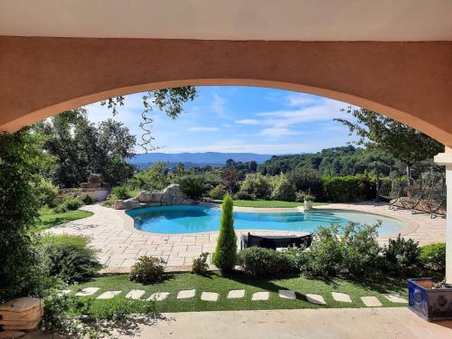 Un arco sobre una piscina en un jardín. en Logement indépendant C & D, en Lorgues