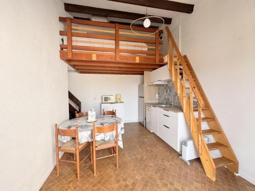 une salle à manger avec une table et un escalier dans l'établissement Agréable Maison Résidence au calme - terrasse- parking privé - 6ANI147, au Barcarès