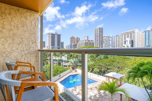 a balcony with a view of a pool and the city at Luana Waikiki Hotel & Suites in Honolulu