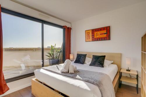 a bedroom with a bed and a large window at Le Rooftop - A 10min de Bordeaux centre in Talence
