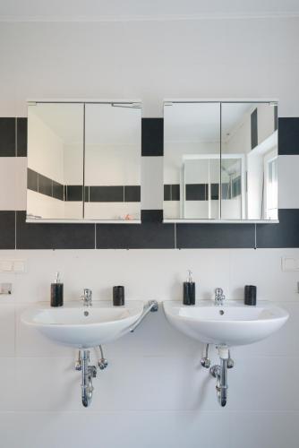 two sinks in a bathroom with two mirrors at Domus Optima - Cozy Retreat in Vienna in Vienna