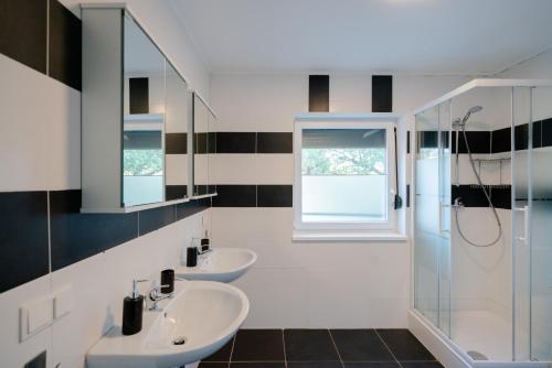 a bathroom with two sinks and two mirrors at Domus Optima - Cozy Retreat in Vienna in Vienna