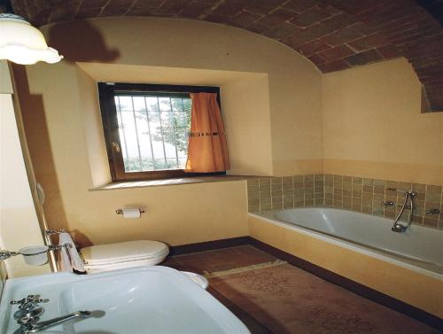 baño con bañera, aseo y ventana en Agriturismo Fonte Senesi, en Monticchiello